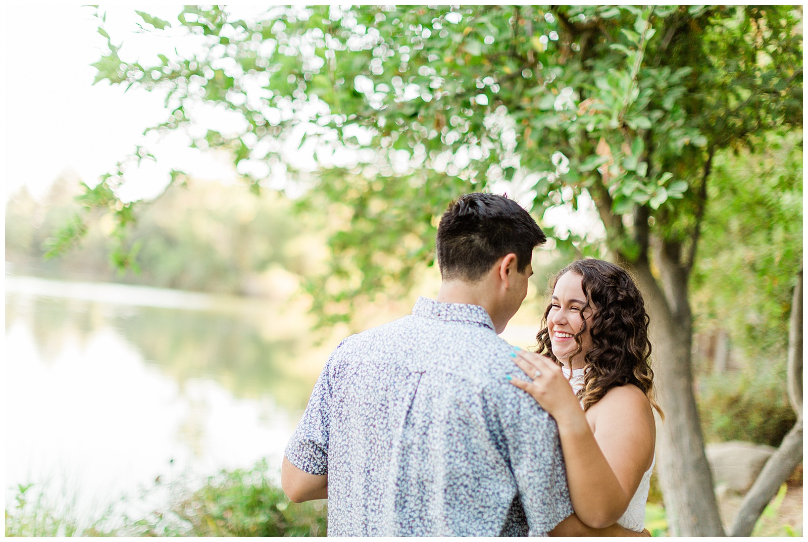 newly engaged couple dancing by a lake