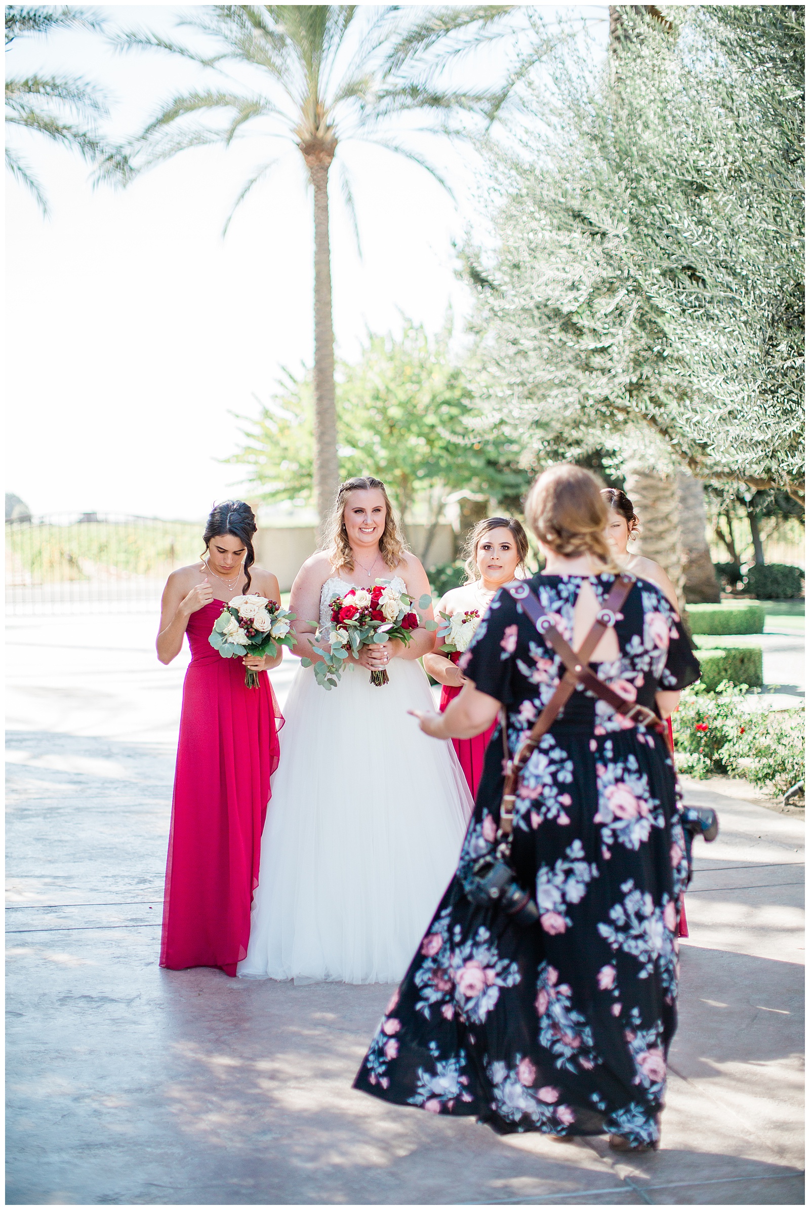 wedding photographer directing bridal party at tuscan gardens venue