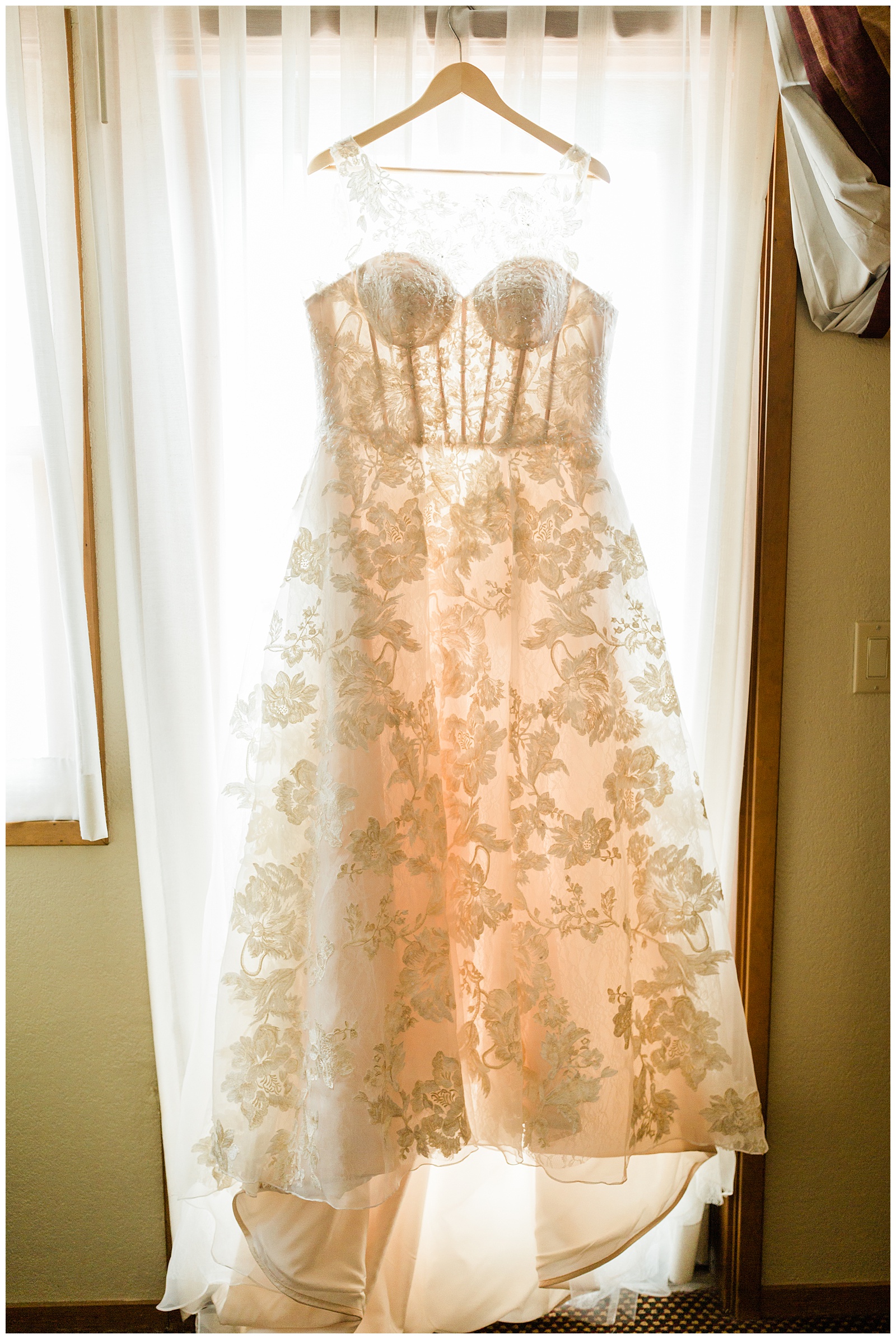 wedding dress hanging in front of a window