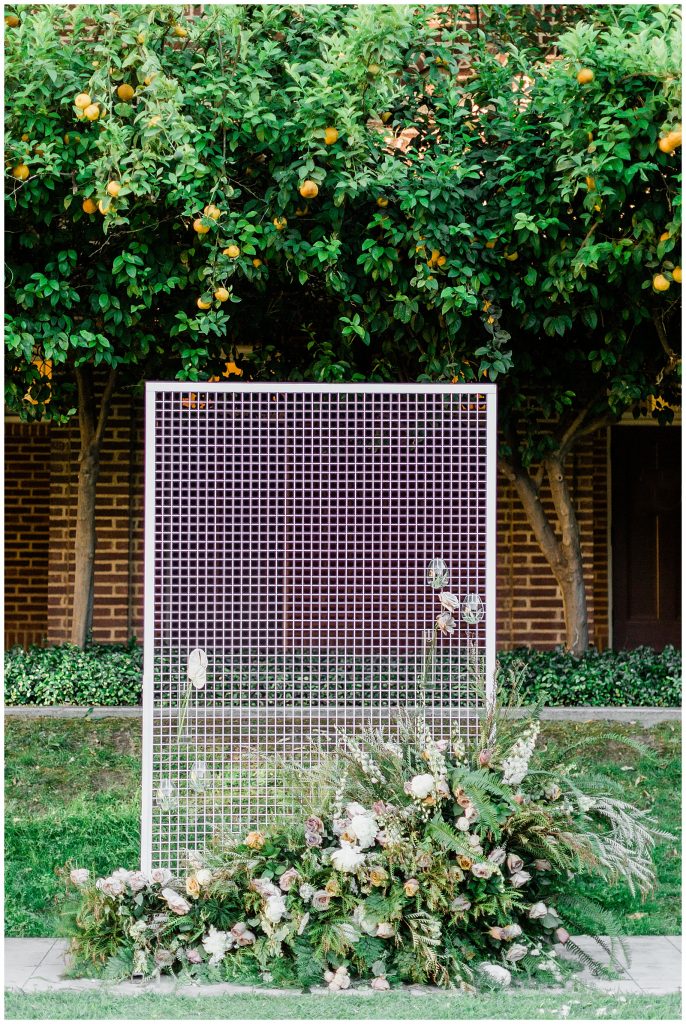 modern wedding ceremony florals and metal arbor with hanging plants