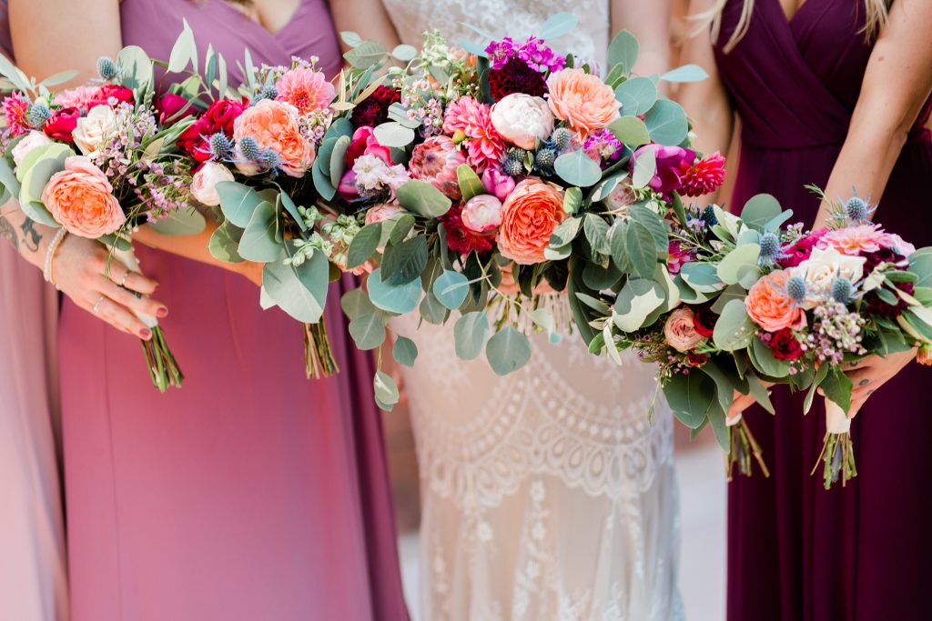 wedding bouquet with pinks, reds, and eucalyptus
