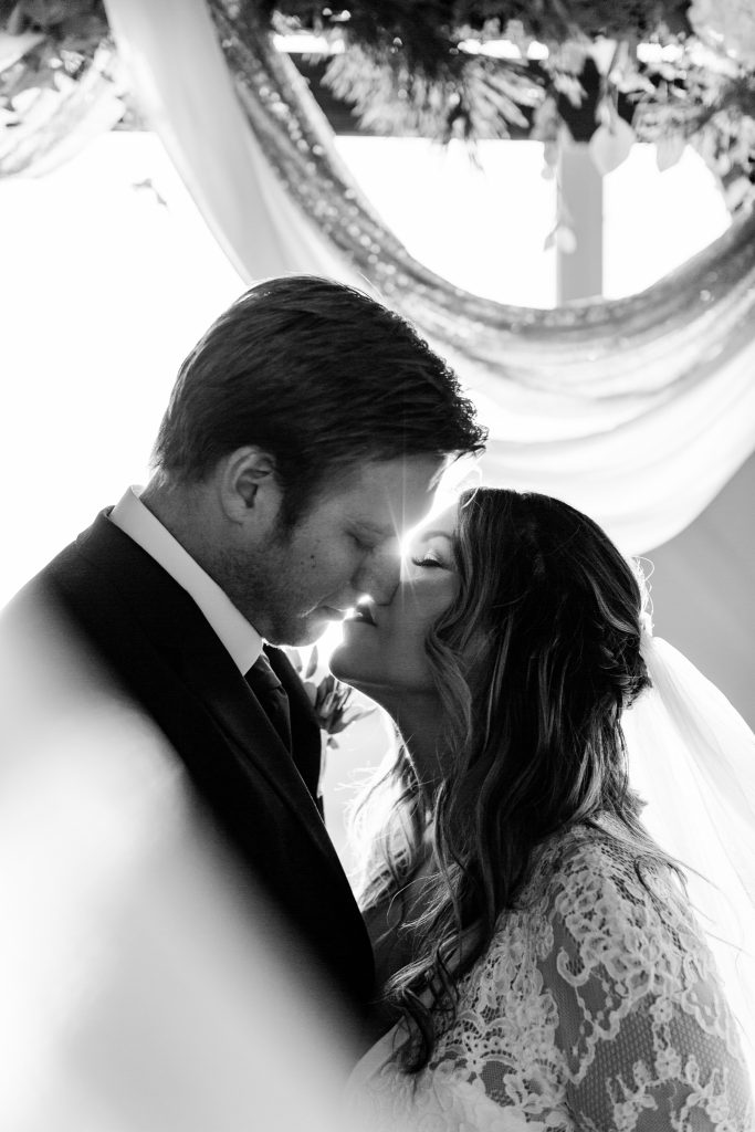 black and white wedding veil shot with the sun flaring through their faces