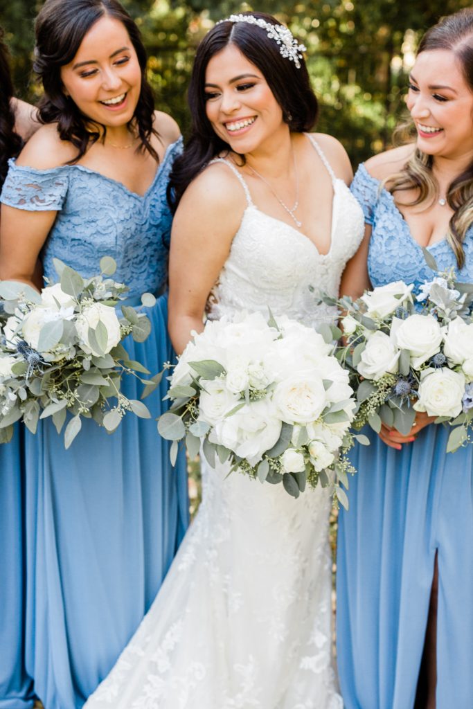 close up of bride and bridesmaids with white bouquets and blue bridesmaids