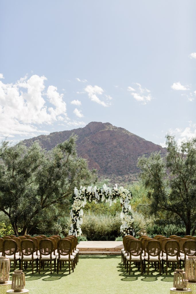 outdoor luxury wedding ceremony with white floral arch