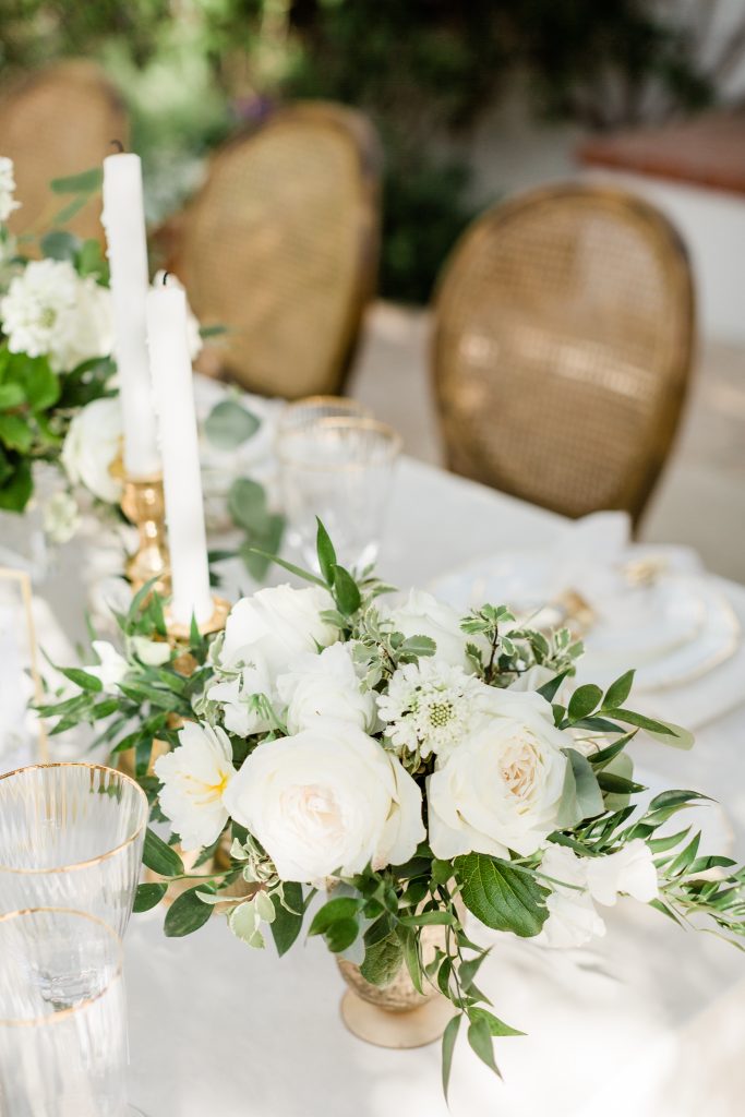 white floral centerpiece with gold vase
