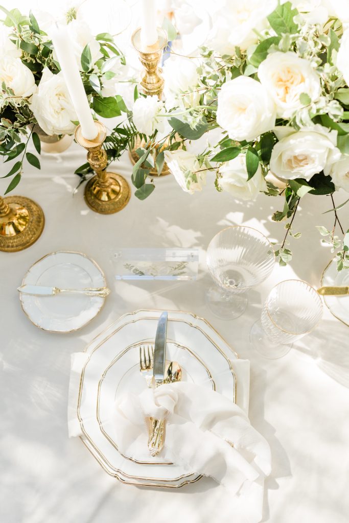 white and gold dinner table setting and centerpiece