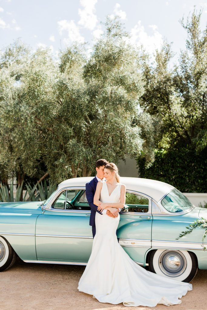 Bride and groom in front of vintage car