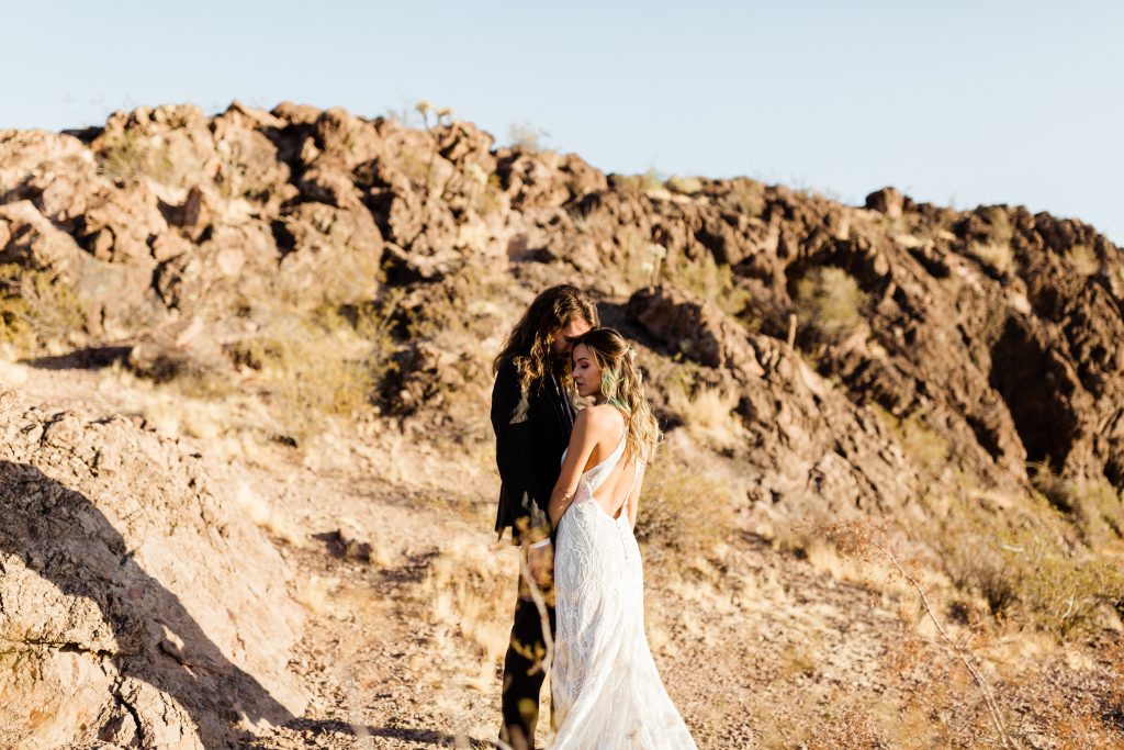 bohemian couple embracing on the cliffs in the tempe desert