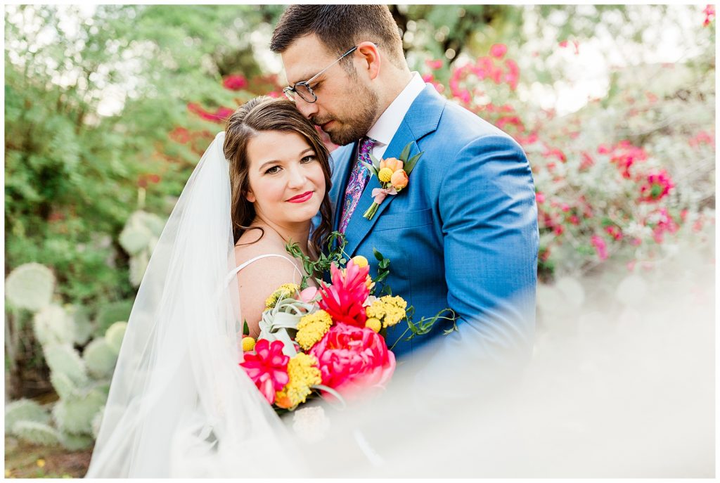 flowing veil with pops of color around bride and groom 