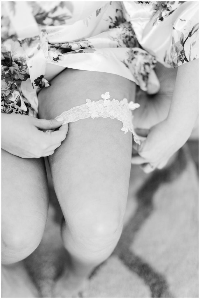 bride putting on lace garter