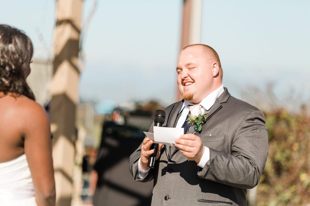 groom laughing and reading vows