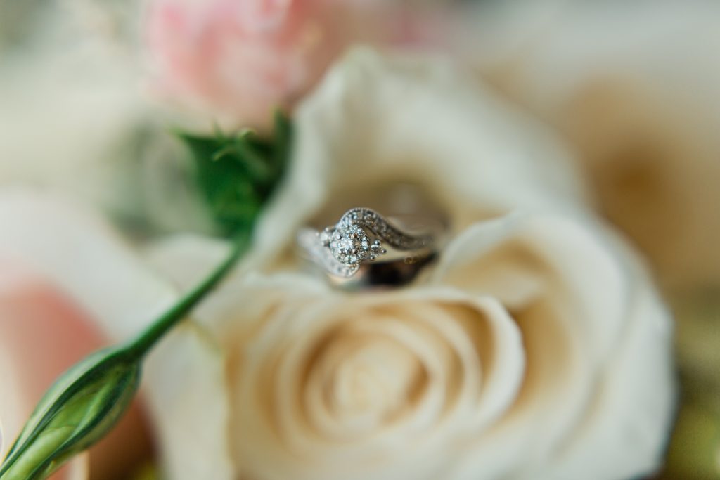 close up of wedding ring in a white rose