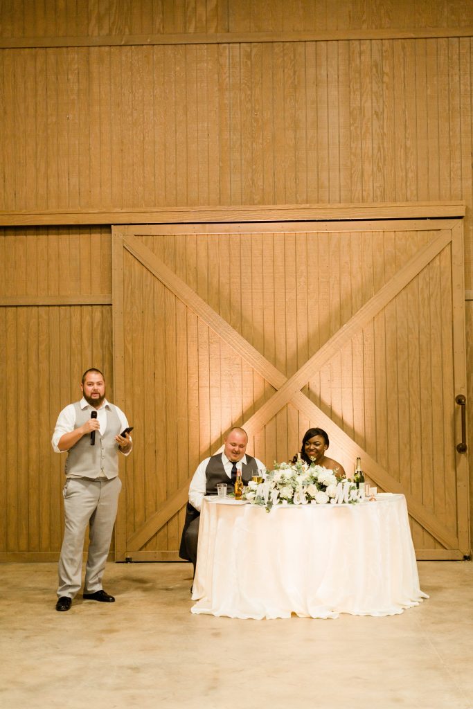 groomsman toast in wooden barn at Kings River Winery
