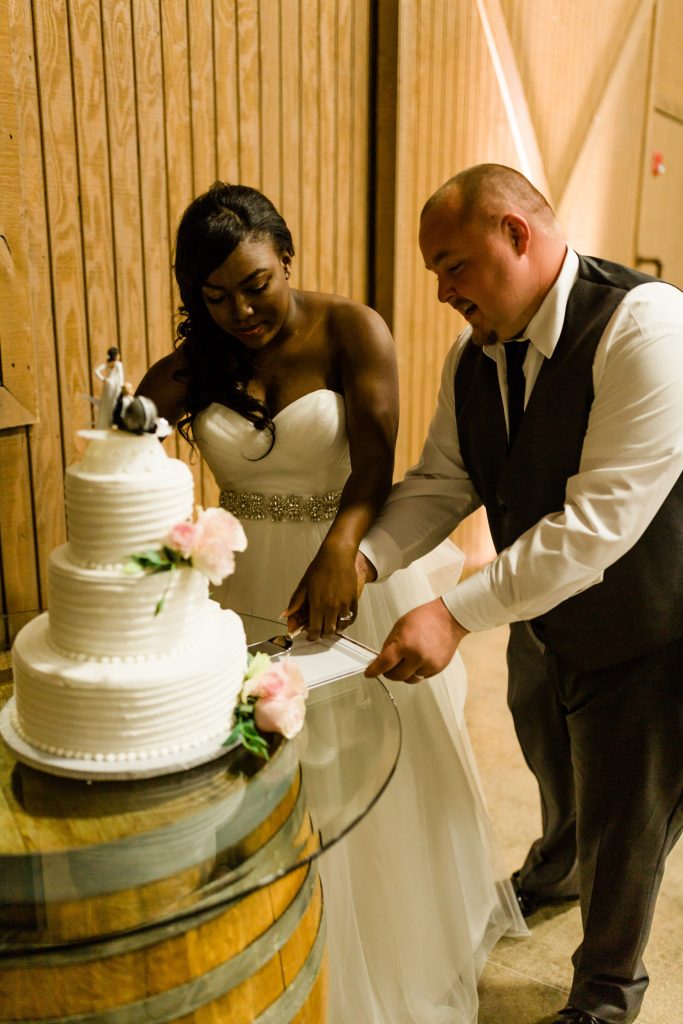 bride and groom cutting 3 tier wedding cake 