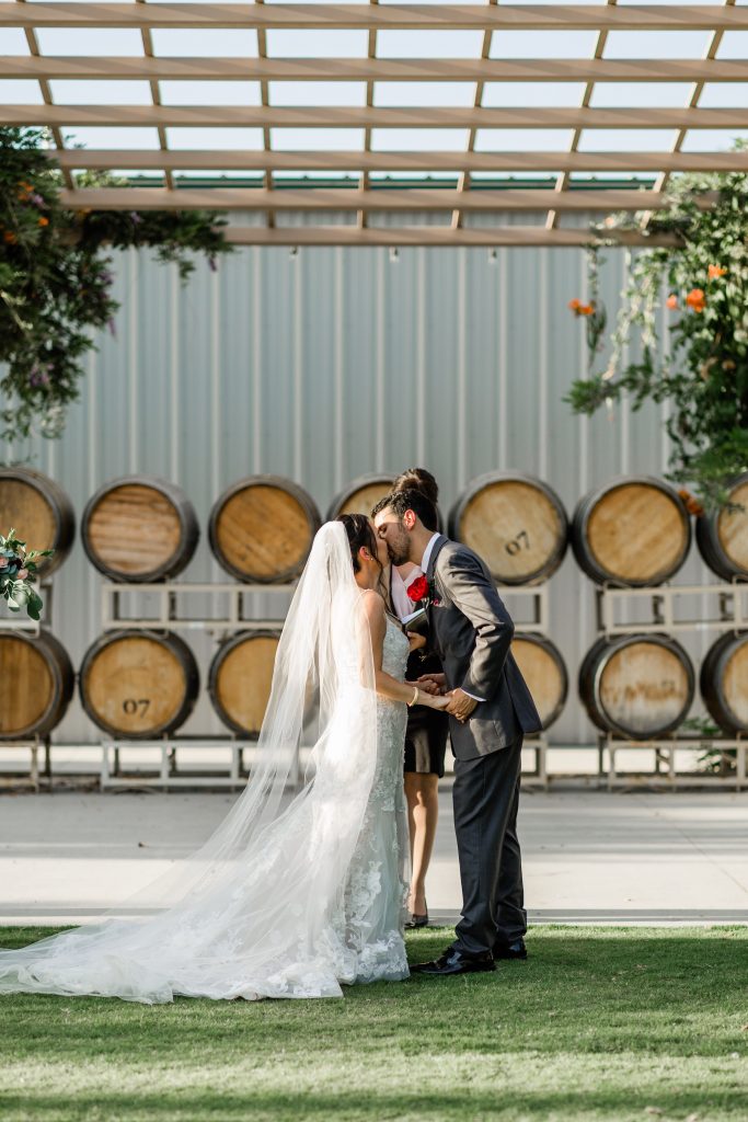 bride and groom kissing for the first time as husband and wife at kings river winery