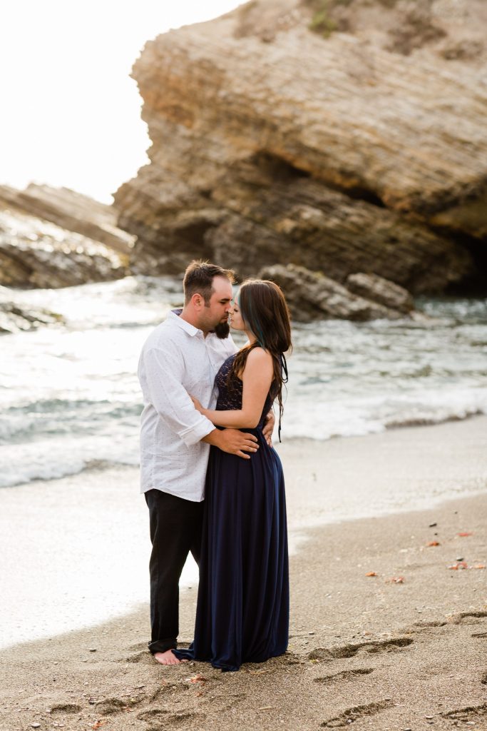 couple about to kiss along the rocky shores of montana de oro