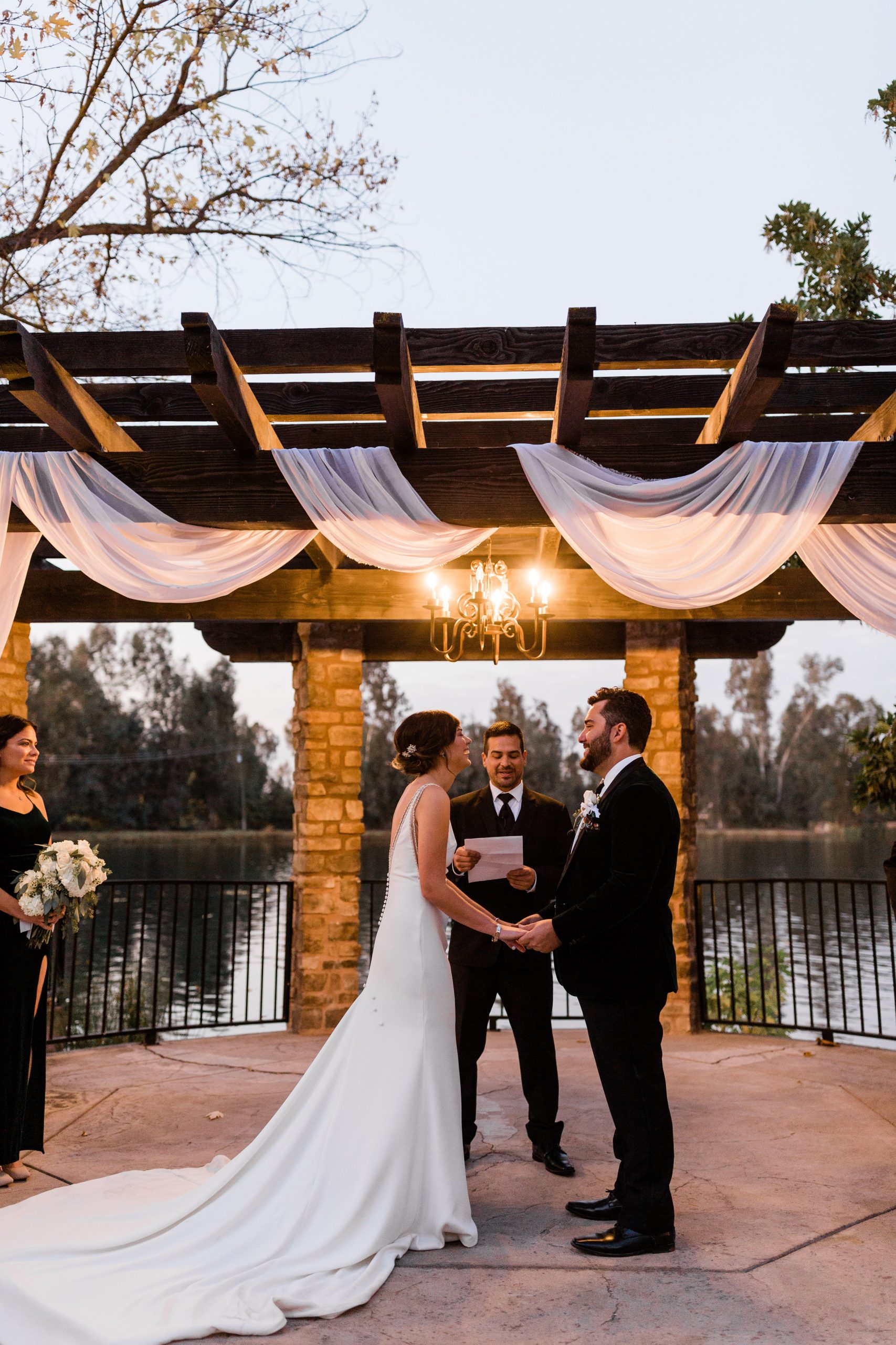 bride and groom holding hands laughing during sunset wedding ceremony wolf lakes park november wedding