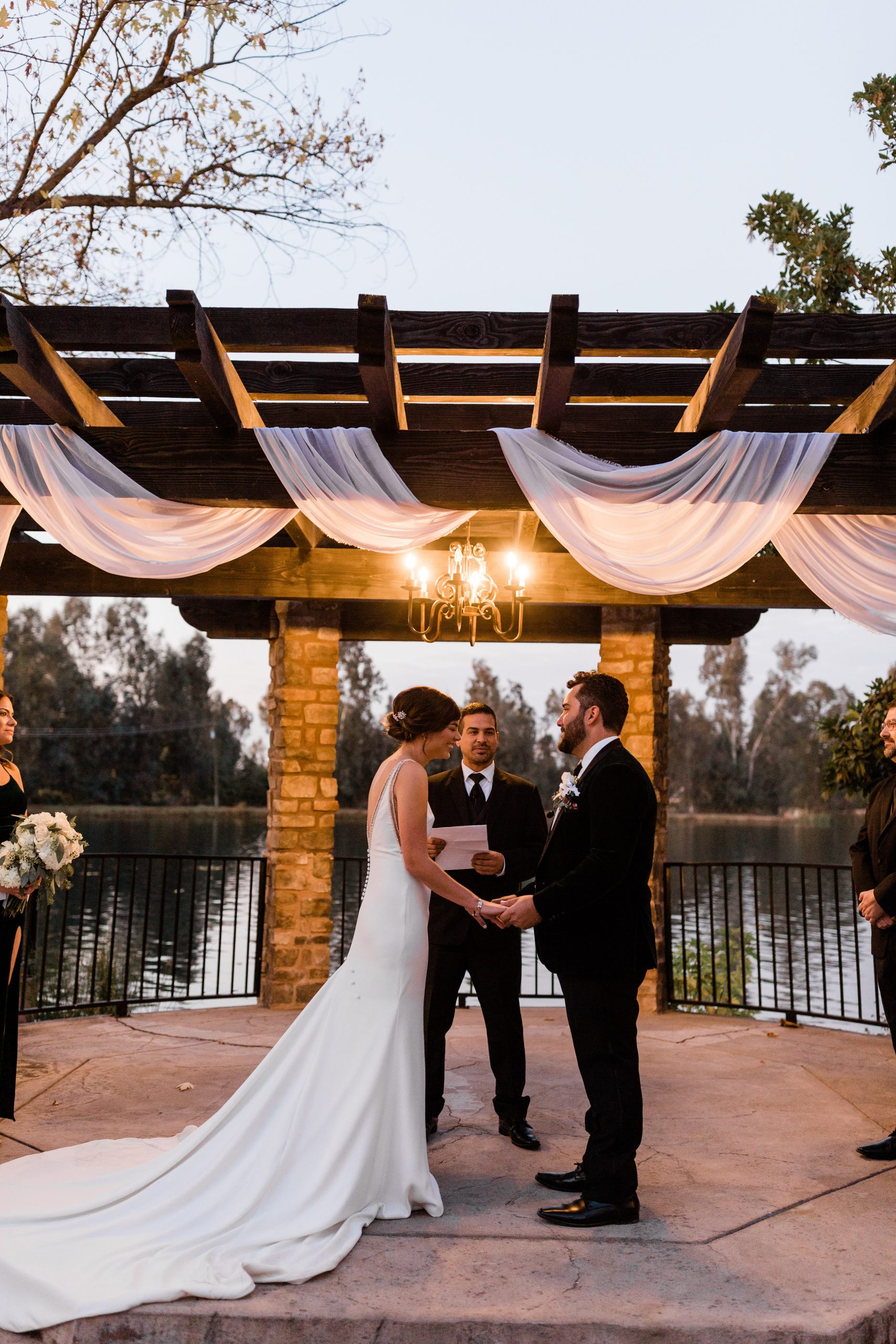 groom and bride holding hands laughing during sunset wedding ceremony wolf lakes park
