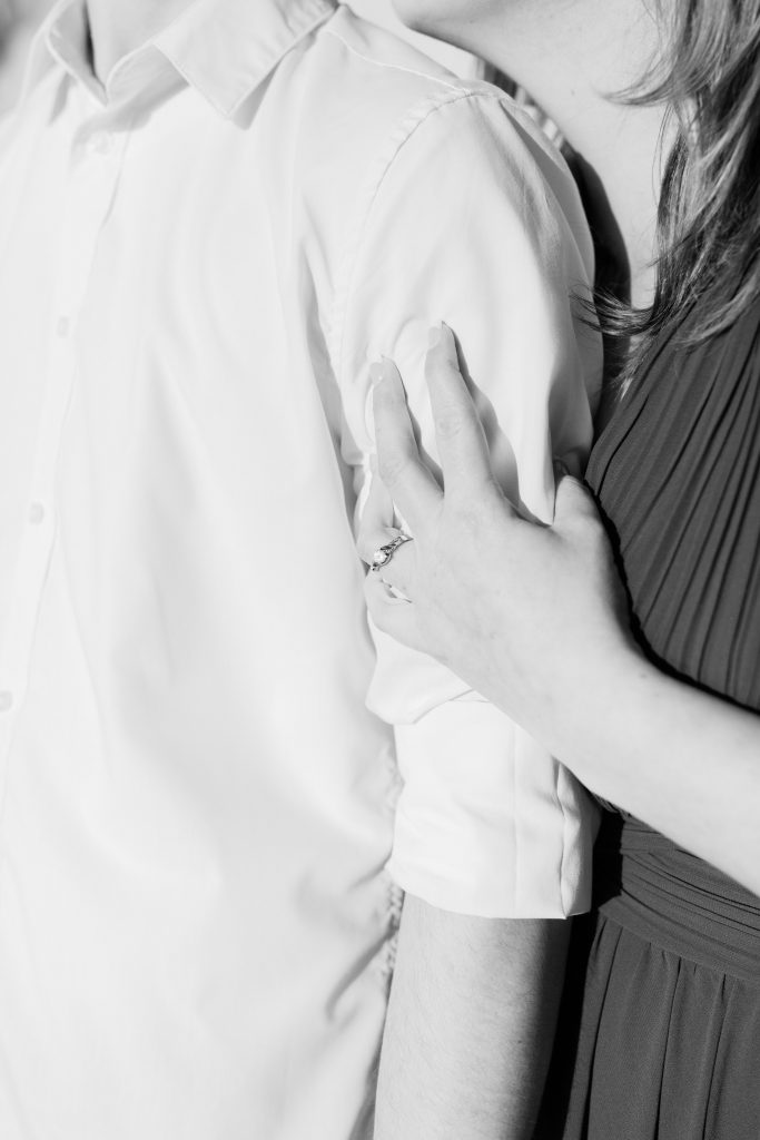 close up black and white shot of an engaged couple embracing 
