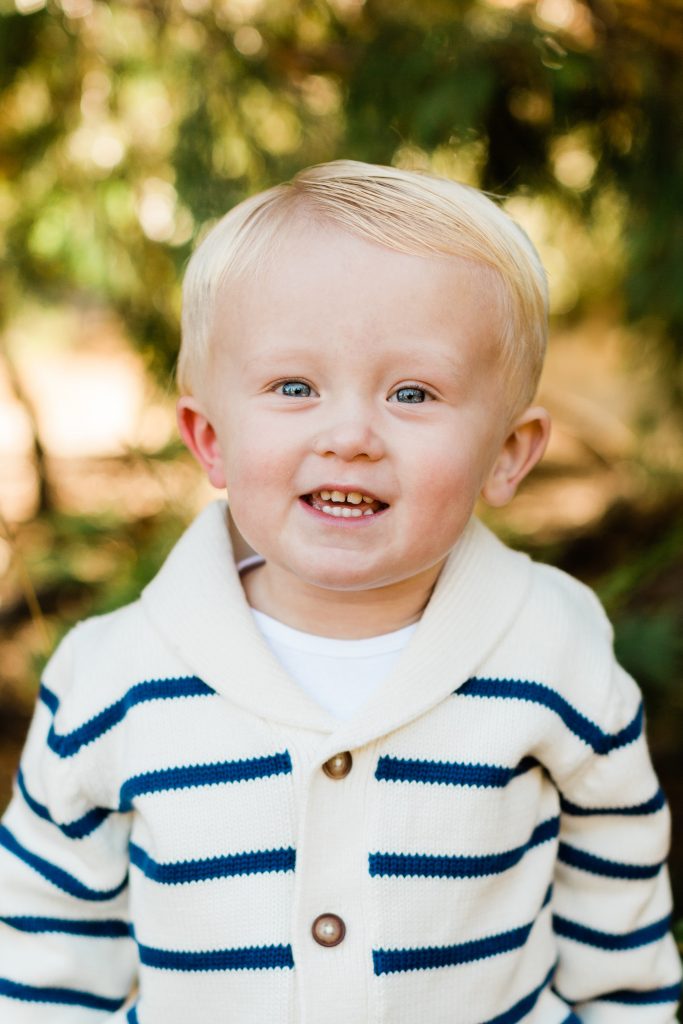 toddler headshots in a white sweater with blue stripes