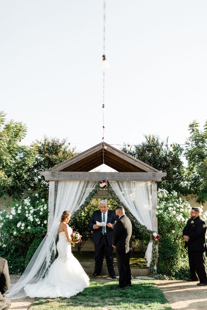 bride and groom standing at the alter of an outdoor wedding ceremony