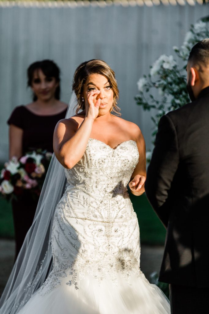 emotional bride wiping away tears during her wedding ceremony