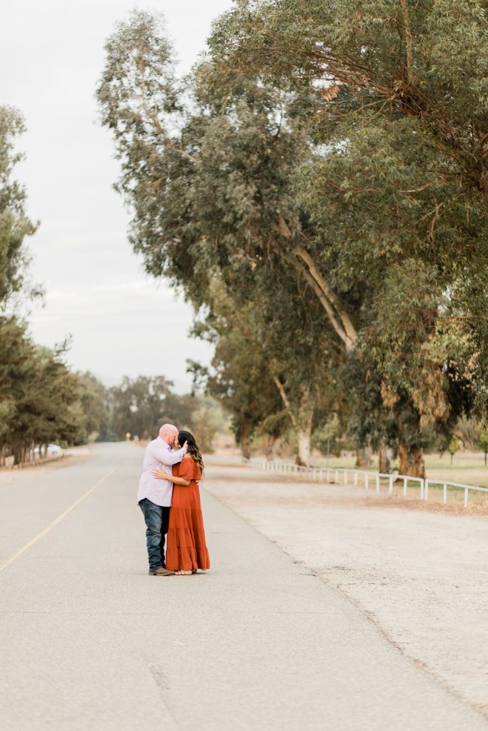 engaged couple kissing in the middle of the road at lost lake park in fresno california