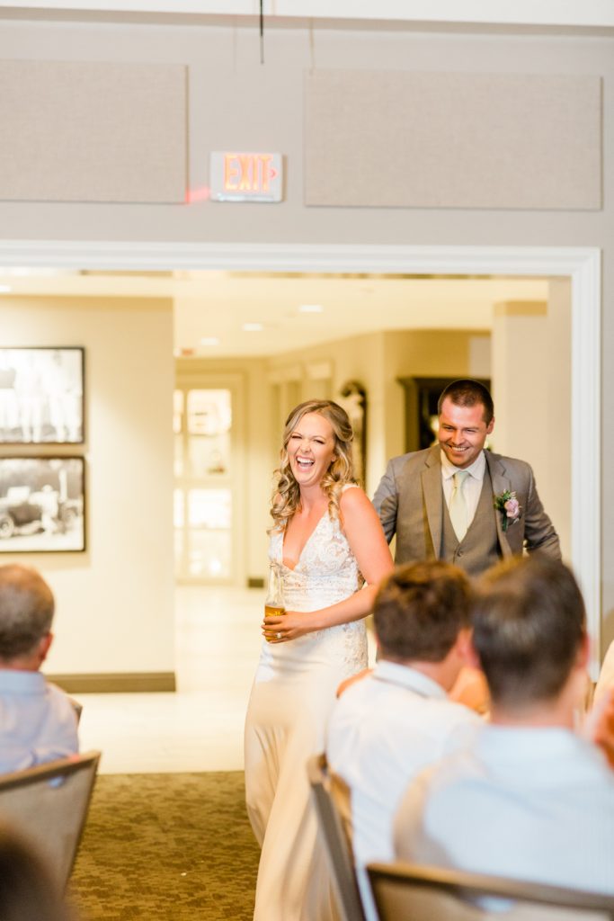 Bride and Groom laughing while entering reception.