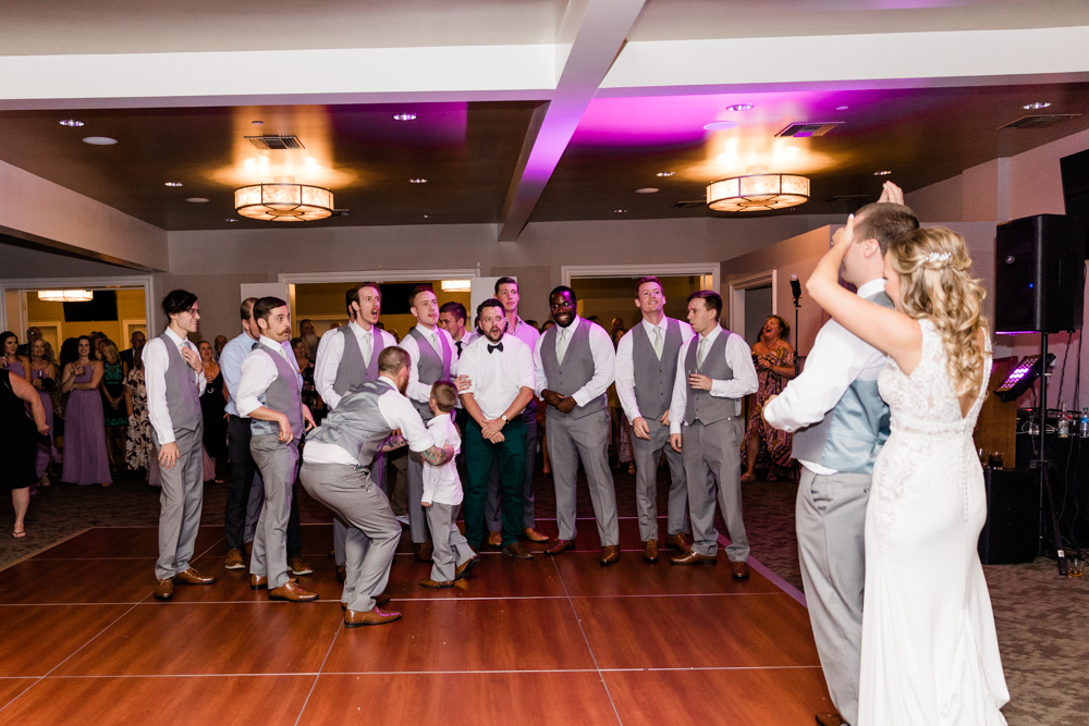 Bride covering grooms eyes to throw the garter
