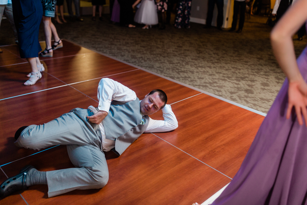Man breakdancing on the floor in a grey suit
