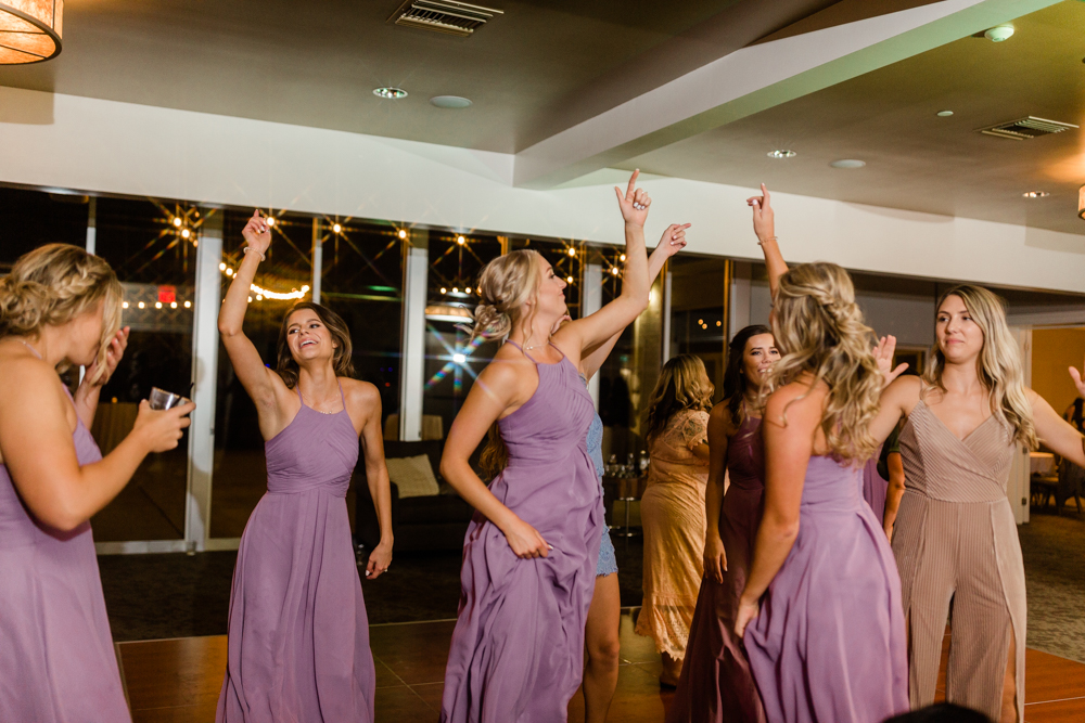 Bridesmaids dancing and jumping in lavender dresses