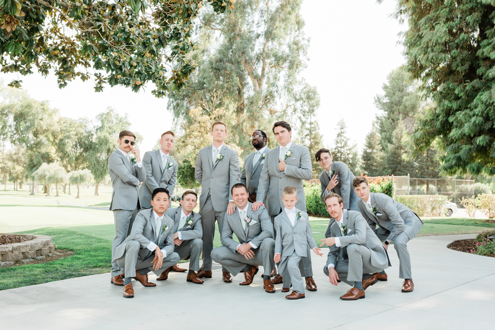 Groomsmen standing together in different poses to be silly