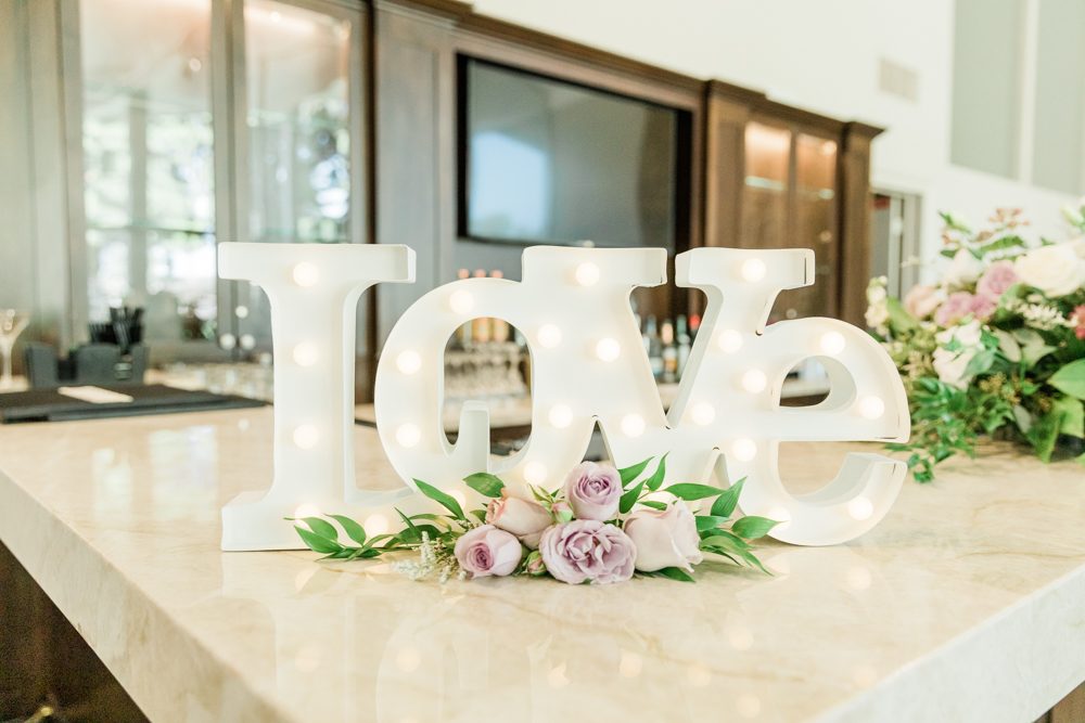 small marquee LOVE sign with white and purple flowers