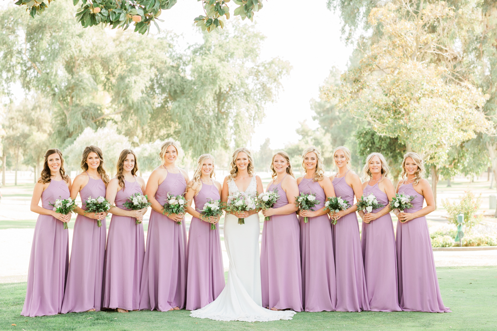 Bridesmaids in lavender lined up with bride outside
