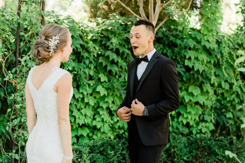 groom excitedly smiling at his bride during their first look at wolf lakes park