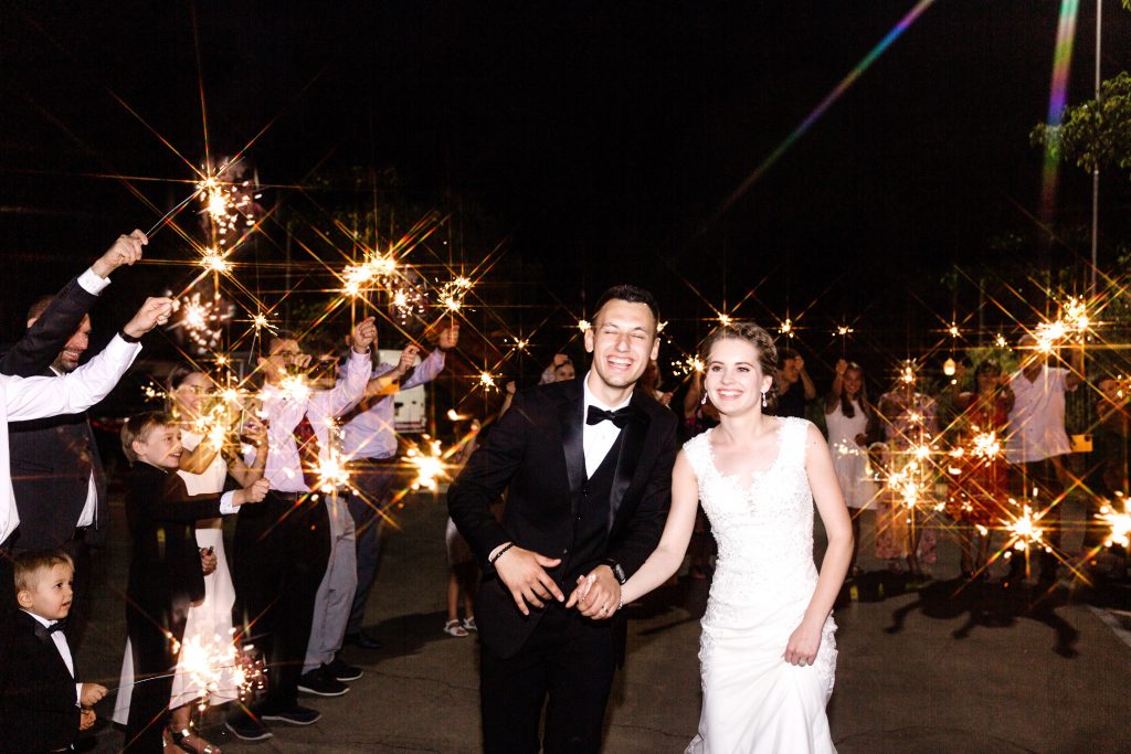 bride and groom holding hands during a sparkler exit at a wedding at wolf lakes park