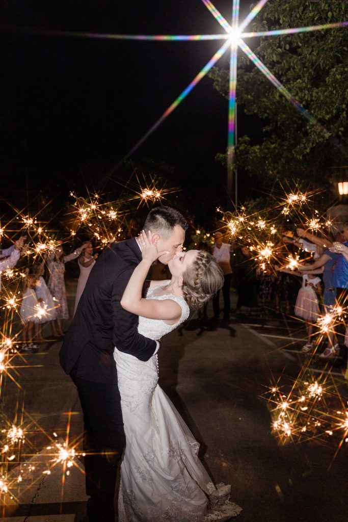 bride and groom kissing during a sparkler exit at a wedding at wolf lakes park by fresno wedding photographer megan helm photography
