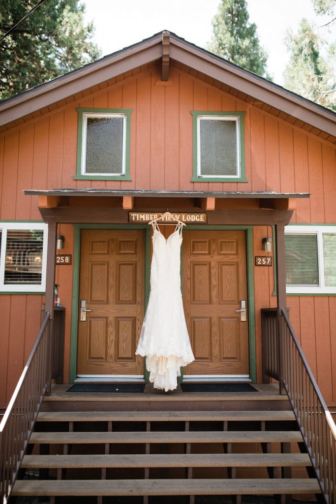 Beaded wedding dress hanging in front of Timber View Lodge at the Pines Resort