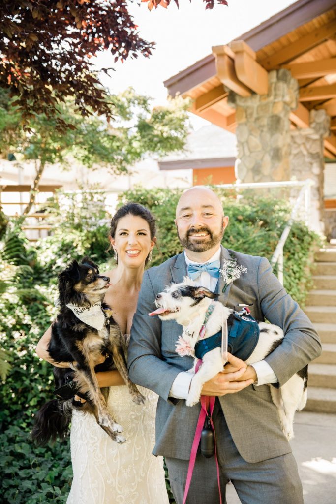 Newlyweds holding their dogs after ceremony