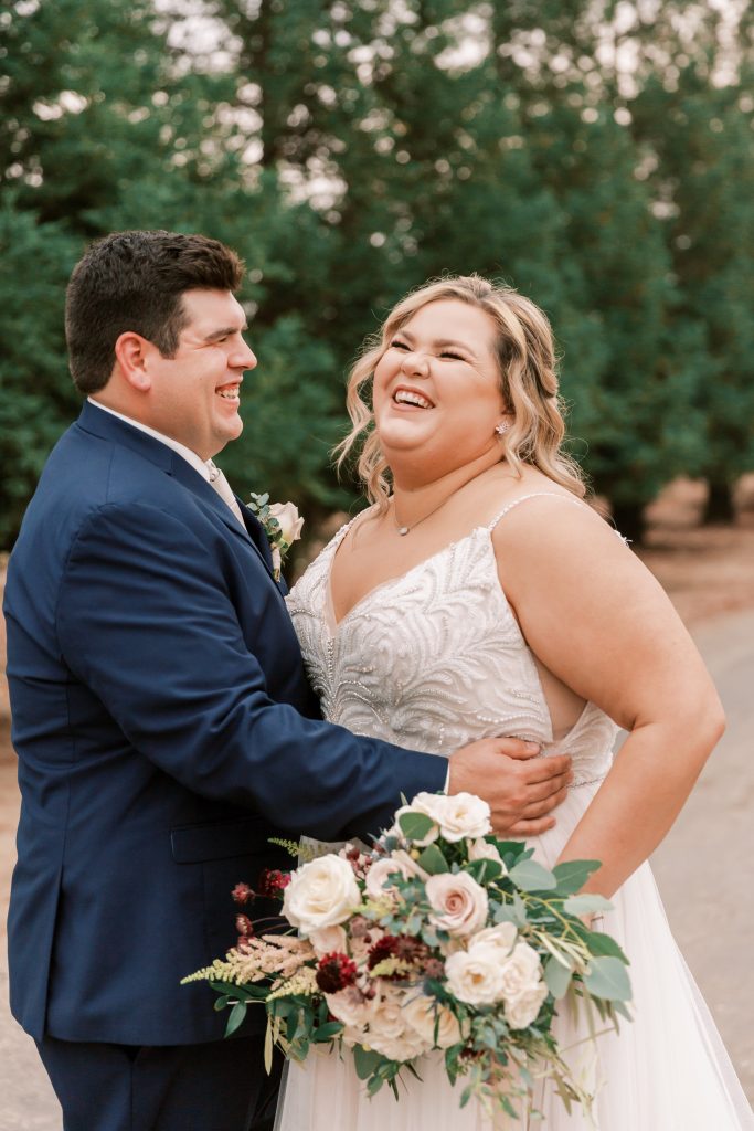 Married couple laughing and hugging on an overcast wedding day