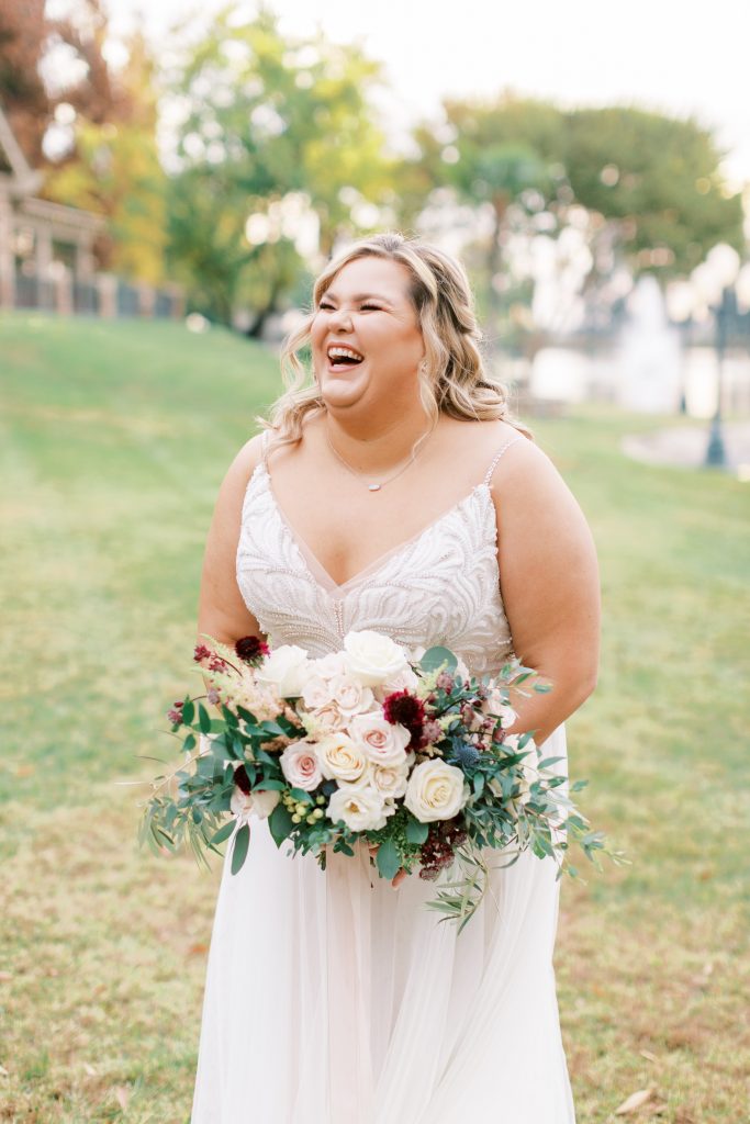overcast wedding photos of a bride laughing joyfully with blush, burgundy, and white bouquet. 