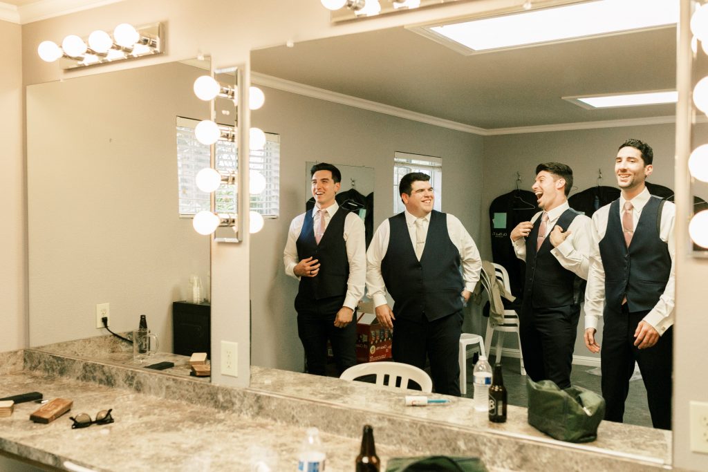 Groomsmen laughing while getting ready at Wolf Lakes Park