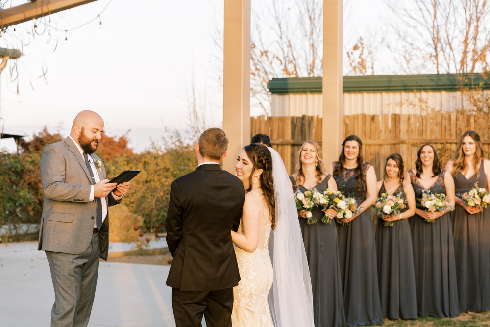 Bridesmaids laughing during ceremony while Bride and Groom look at each other. 