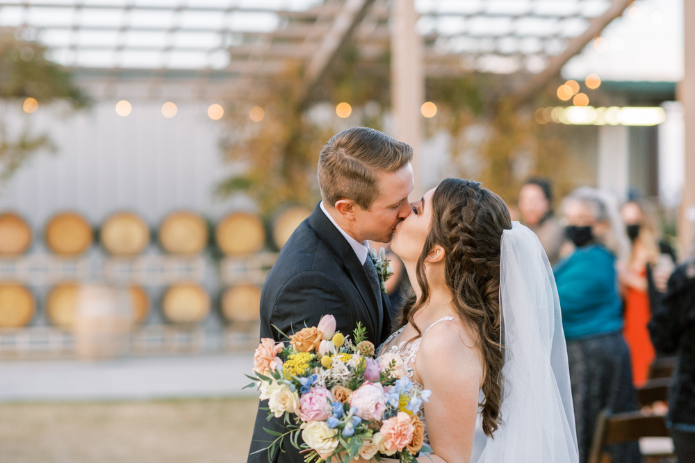 bride and groom kissing after winery wedding ceremony at kings river winery