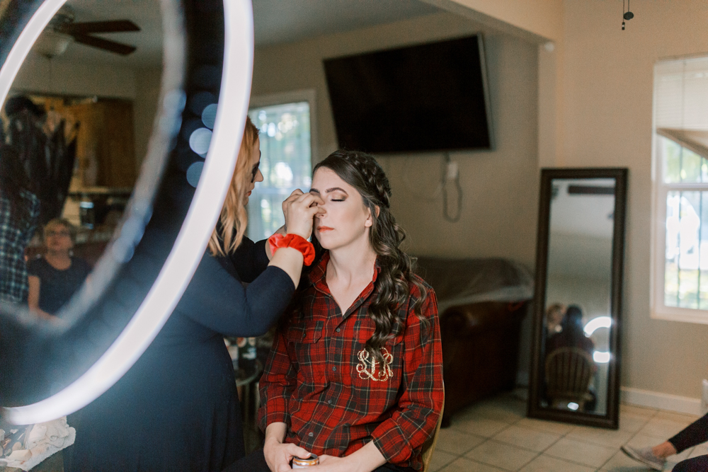 Bride in red flannel getting her make up done in Kings River Winery wedding bridal suite.