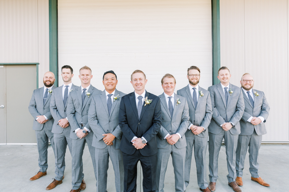 Groomsmen in light grey suits with groom in charcoal grey suits. 