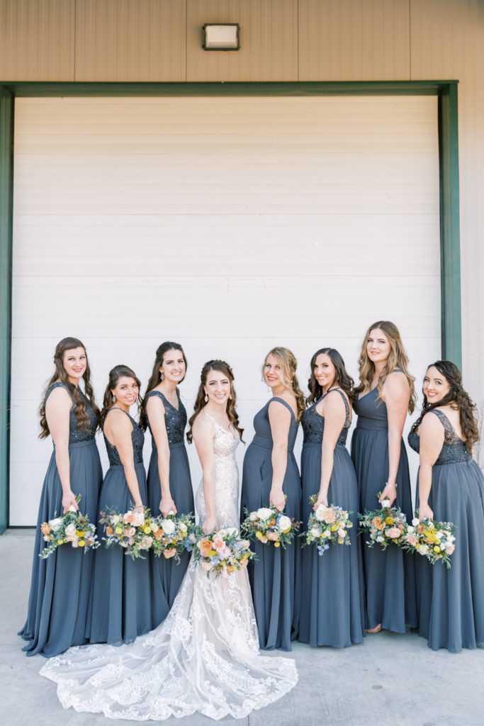 Bridesmaids in grey dresses with colorful bouquets at a Kings River Winery wedding
