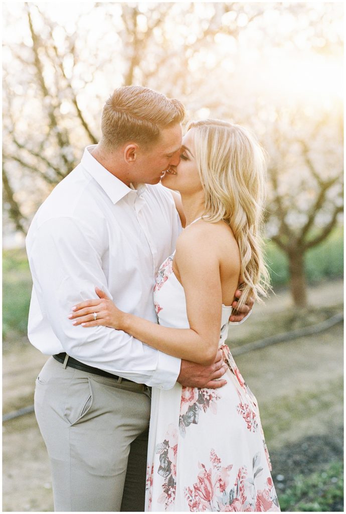 Film portrait of couple about to kiss in tree field