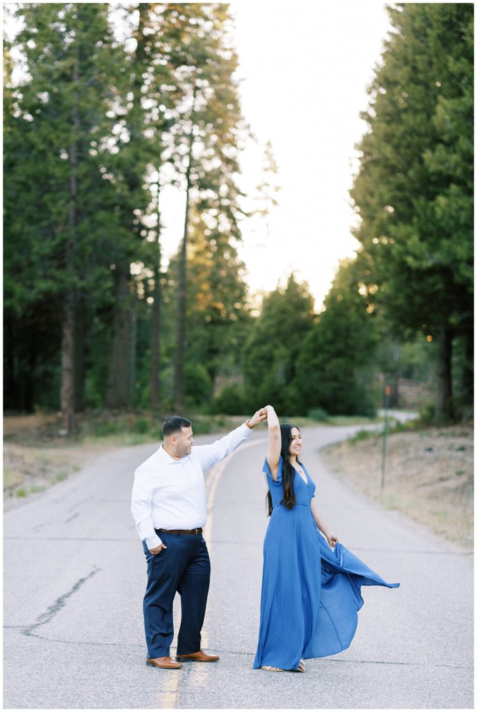 engaged couple dancing in the middle of an empty road