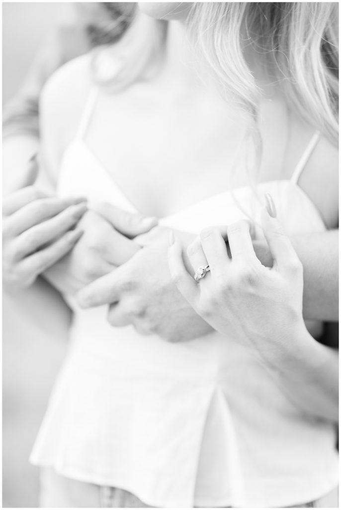 black and white close up of engagement ring and hands embracing